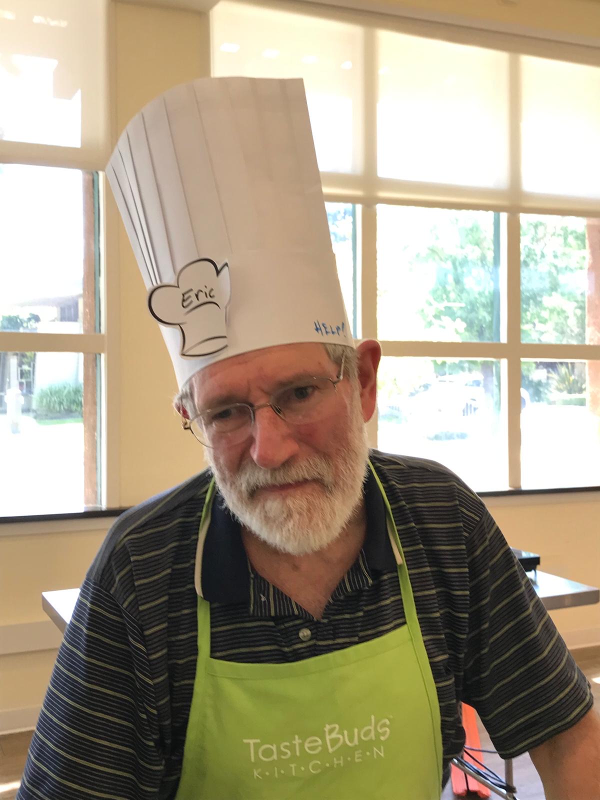 Eric at family cooking class in paper chef hat